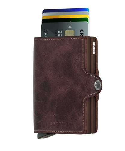 Secrid Wallets Twinwallet with a brown leather cover and metal card-holder, showcasing its lever-ejected card feature, holding 2-6 cards, cash, and business cards.