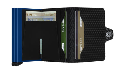 Secrid Wallets Twinwallet open, showing a blue cash-clip with euros, textured black cover holding three credit cards, and a snap-button flap for closure.