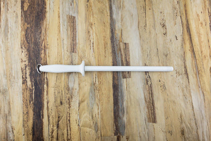 Knifewear White Ceramic Honing Rod on wooden surface, featuring a cylindrical rod with handle and ring, ideal for maintaining sharpness in ultra-hard knife steels.