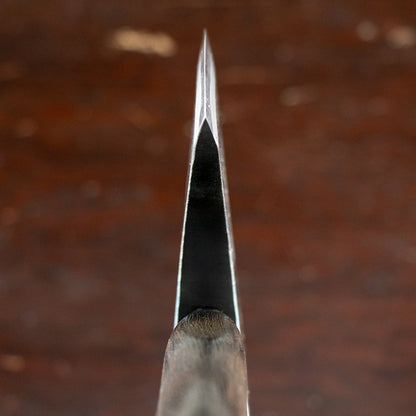 Mizuno Axe Hatchet close-up: head-on view down the blade's spine, showcasing its precise chisel-style grind and wooden handle, designed for versatile chopping tasks.