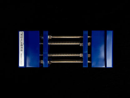 Stone Holder Spring Loaded with blue jaws and threaded rods, designed for easy, secure grip of sharpening stones. Made in Japan label visible on left block.