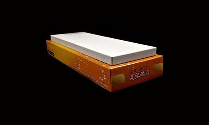 Naniwa Specialty/Super Stone 5000 210x70x10mm sharpening stone displayed on its packaging, ideal for honing kitchen knives and cutting tools, offering precision without excess steel removal.