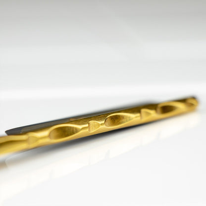 Macro shot of Dovo Straight Razor, Bergischer Horn Handle, 5/8, showcasing its titanium-nitride coated twist-type drill bit on a shiny surface.