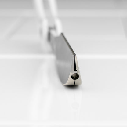 Feather Artist Club DX Folding Handle Shaving Razor with stainless blade and hinge, open on a white surface, showcasing its precision and design innovation.