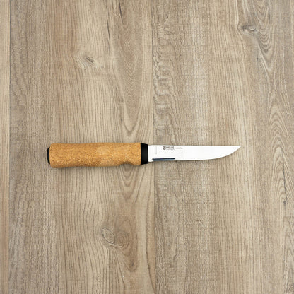Helle Knives Hellefisk 123mm Fishing and Hunting Knife with a thin stainless steel blade and floating cork-wood handle on a wood-grain surface.