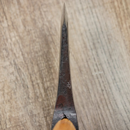 Close-up of Hultafors Hultan Hatchet's blade with wooden handle, highlighting its craftsmanship and durability for outdoor tasks, set on a wood-grain surface.
