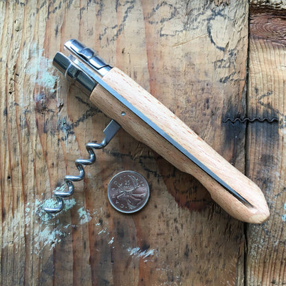 Opinel Inox No.10 Folding Knife with a wooden handle and stainless steel blade, shown next to a Canadian 25¢ coin for size reference.