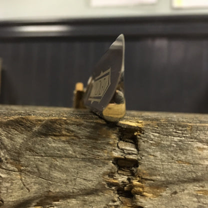 Dovo Encina Straight Razor with Spanish Oak handle, 6/8 blade, sits elegantly on a weathered tabletop, reflecting classic craftsmanship and precision.