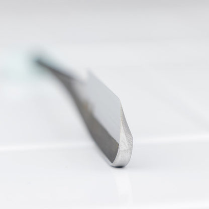 Close-up of an Iwasaki Kamisori chisel blade, showcasing its sharp cutting edge, crafted for precision and ergonomic use in traditional shaving.