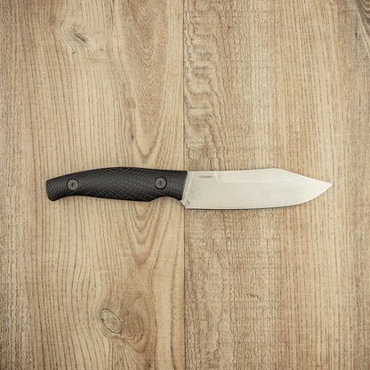 Kershaw Camp 5 knife with a durable D2 steel blade and textured black handle, designed for bushcraft and hunting tasks, displayed on a wooden surface.