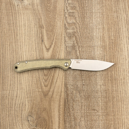 Kershaw Federalist knife with a stonewashed blade stamped 4320 USA, and a textured micarta handle, showcasing classic craftsmanship on a wooden surface.