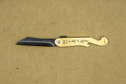 Mujun Mt. Fuji Folding Knife features a black blade folding into a brass handle with Japanese engravings, including a bottle opener, showcasing traditional Japanese craftsmanship.