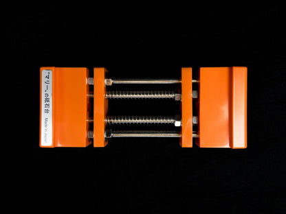 Stone Holder Spring Loaded secures sharpening stones with adjustable orange jaws and threaded rods, ideal for precise sharpening tasks. Made in Japan, offers ease and efficiency.