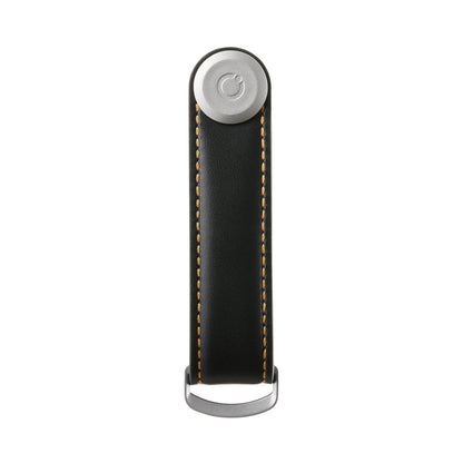 Orbitkey Leather Key Organizer, a black leather strap with contrasting stitching, secures 2-7 keys under a metal stud, featuring a D-ring for easy attachment.