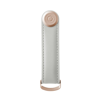 Orbitkey Leather Key Organizer with white leather strap, rose-gold button, and D-ring for attaching keys, designed for organized, quiet carrying.