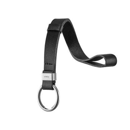 The Orbitkey Strap, a sleek black leather wrist lanyard, features a metal clasp and key ring, offering easy key retrieval and organization.
