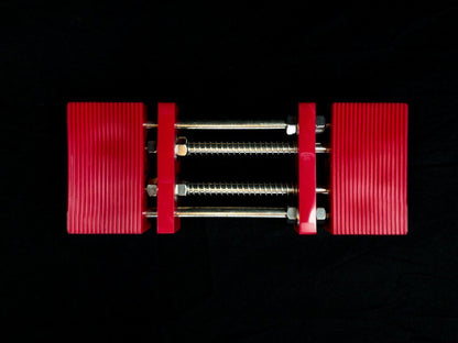 Stone Holder Spring Loaded: A small parallel-jaw clamp with ribbed red plastic jaws and steel rods, ideal for securing stones in crafting or woodworking projects.
