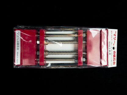 Stone Holder Spring Loaded in clear packaging with red plastic ends and steel rods, designed for easy, secure sharpening stone placement. Made in Japan.