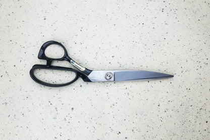 Hidekane No.501 Fabric Shears 240mm with black handles and long metal blades, ideal for precise fabric cutting, showcased on a light speckled surface.