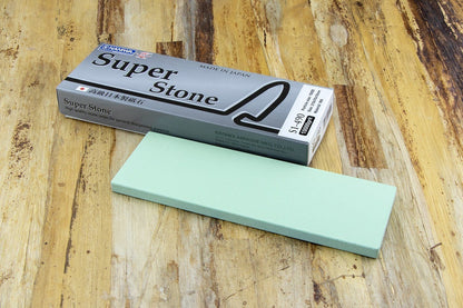 Naniwa Specialty/Super Stone 10000 210x70x10mm, a high-grit sharpening stone for honing knife blades, displayed with its packaging on a wooden surface.