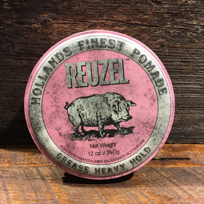 Reuzel Grease Heavy Pink pomade tin on rustic wood, featuring a pig illustration. Offers extreme hold and low-medium shine for all hair lengths and styles.