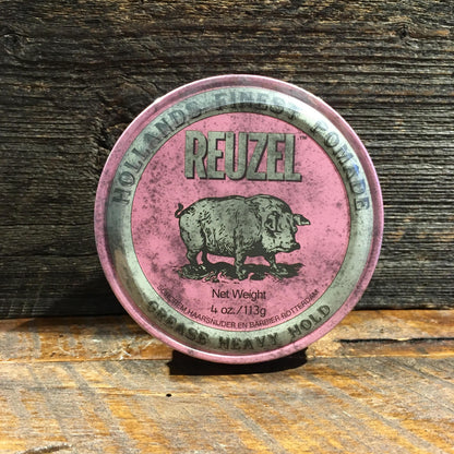 Reuzel Grease Heavy Pink, a vintage-style pomade tin with a pig illustration, offers strong hold for versatile styling, perfect for classic grooming enthusiasts.