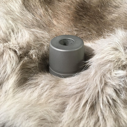 Rockwell Razors Stainless Steel Stand for Double Edge Safety Razor, a machined metal cylinder, sits on a light-gray faux-fur surface. Razor not included.
